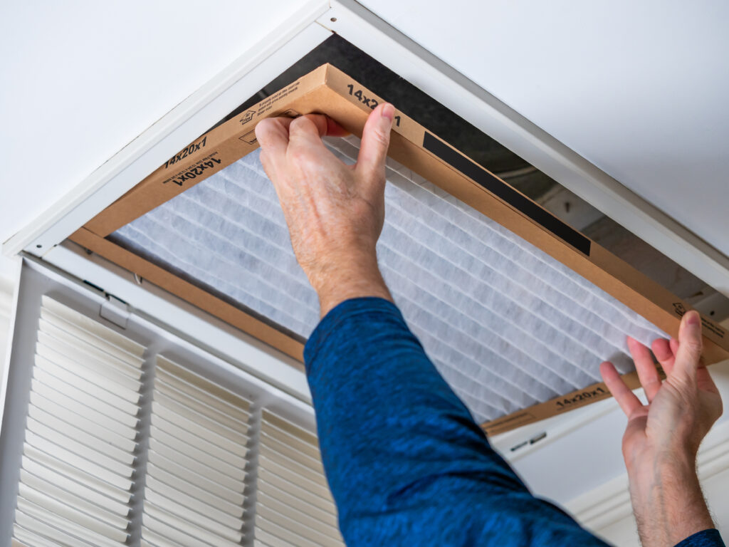 HVAC technician replacing a home air filter in Alhambra