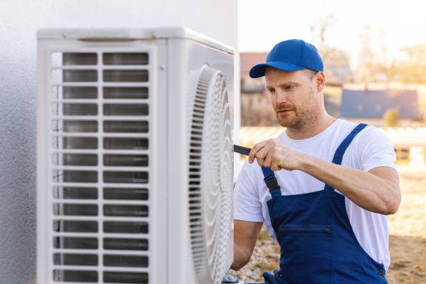 HVAC technician servicing an outdoor air conditioner in Alhambra